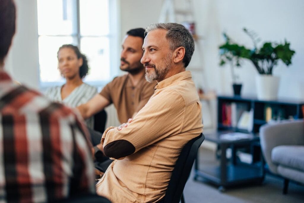 a man listens intently during his group therapy session